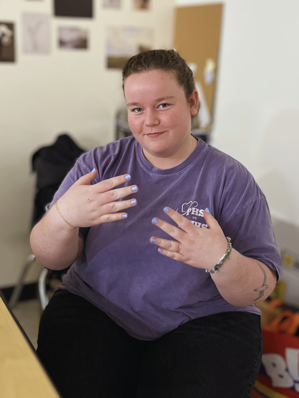 Ms. Bennett enjoys expressing herself through her choice of nail color for the week; this week's color seems to be a light blue with a faint purple undertone.